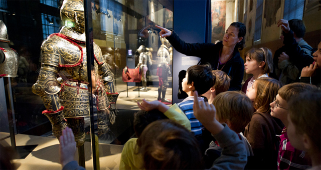 enfants regardant une armure dans une vitrine