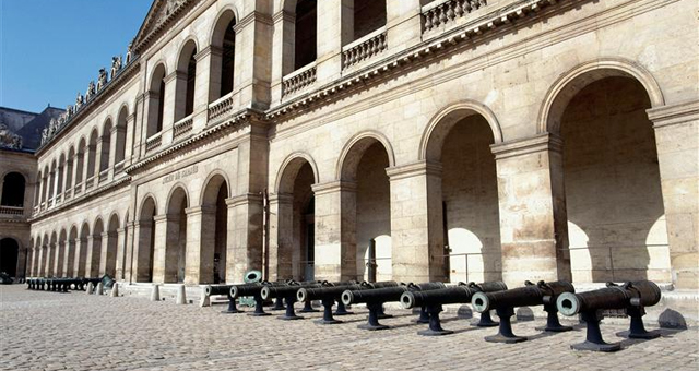 Photo de la cour d'honneur de l'hôtel national des Invalides avec des canons au premier plan