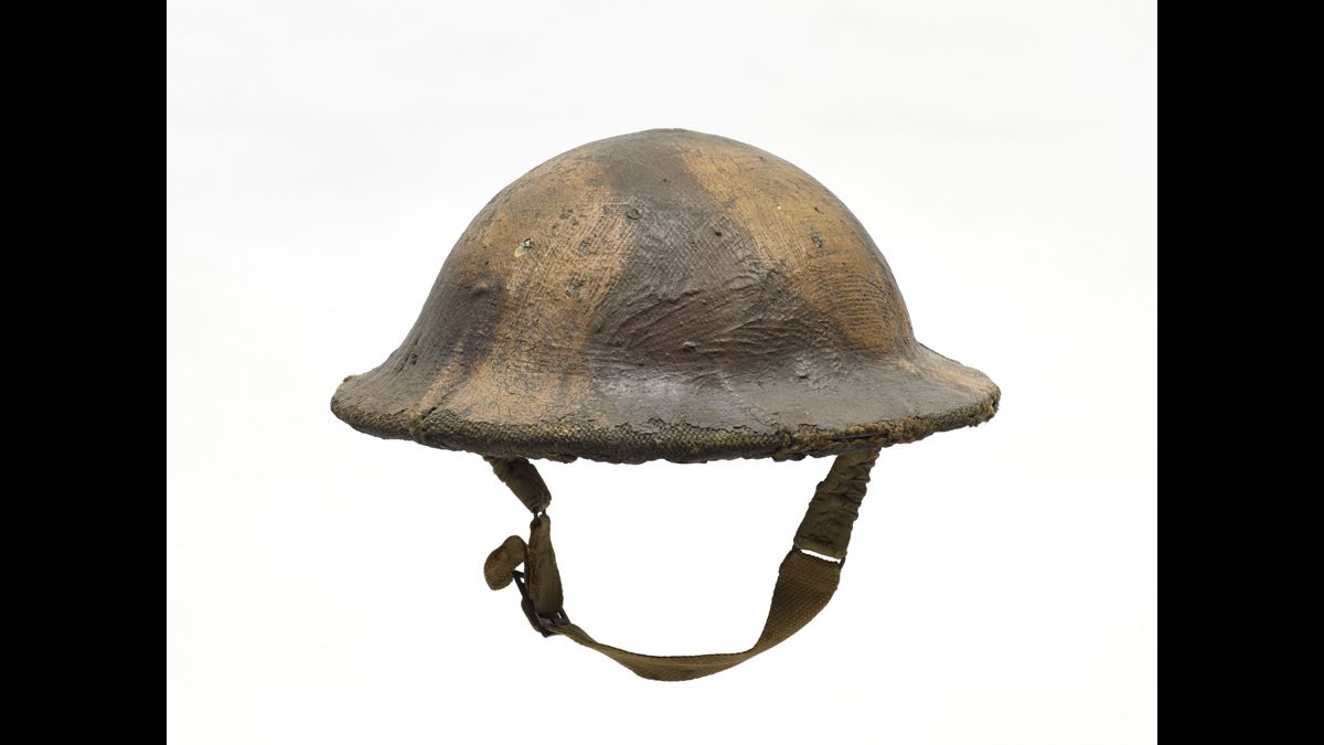 Casque britannique mark II - Ce modèle est recouvert d’une toile de jute camouflée. Ce casque a été retrouvé dans le secteur de Lens dans les années 1980. / collection particulière © Paris - Musée de l'Armée, Dist. RMN-Grand Palais - © Emilie Cambier