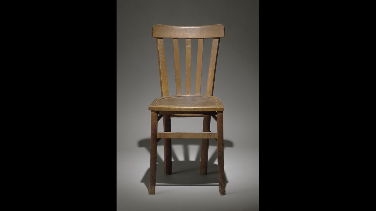 Chaise en bois trouvée en 1944 au siège de la Gestapo à Paris, 84 avenue Foch. Sous le siège se trouve le message d'un résistant capturé et torturé par la Gestapo : "En toute amitié à mes camarades féminins et masculins qui m'ont précédé et qui me suivront dans cette cellule. Qu'ils conservent leur foi. Que Dieu évite ce calvaire à ma bien-aimée fiancée". / Paris, musée de l'Armée © Paris - Musée de l'Armée, Dist. RMN-Grand Palais / Laurent Sully-Jaulmes