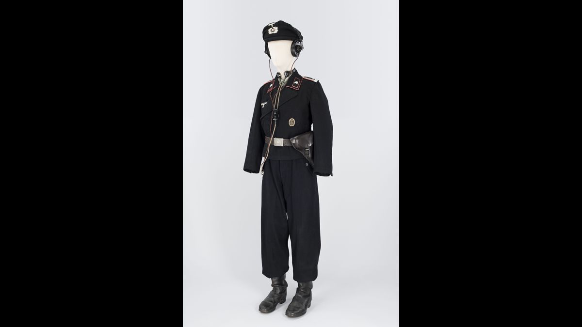 Feldwebel (adjudant)  du 1. Panzer-Regiment 8  (10. Panzerdivision)  - Ce sous-officier porte l’uniforme spécial en drap noir adopté en 1934. Avec les écouteurs  et le laryngophone, ce Feldwebel communique avec les autres chars grâce à l’appareil radio qui équipe les chars Pz KpfW IV du Panzer-Regiment 8. / Paris, musée de l’Armée, inv. Ha 132 © Paris - Musée de l'Armée, Dist. RMN-Grand Palais / Emilie Cambier