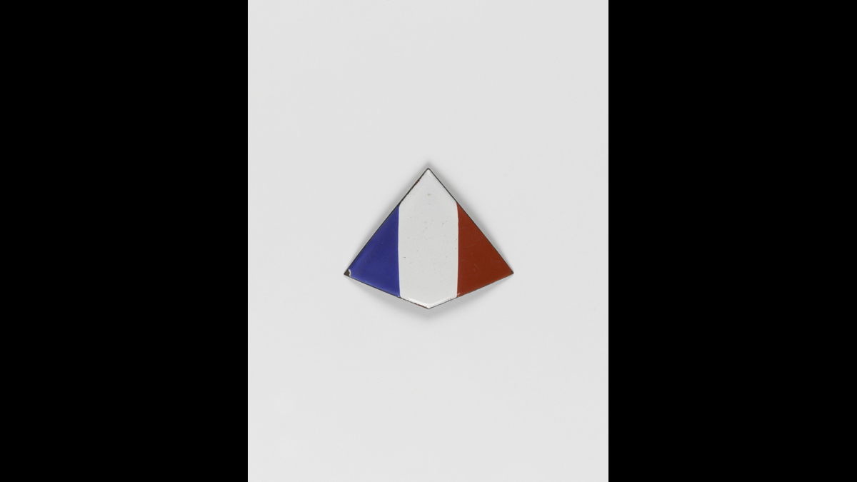 Ecusson tricolore émaillé, premier modèle pour casque colonial - Les premières troupes des Forces françaises libres envoyées en Afrique sont équipées de ce modèle destiné à être monté sur un casque colonial. / Paris, musée de l'Armée, inv. 999.1449. Donc de M. Laignel © Paris - Musée de l'Armée, Dist. RMN-Grand Palais / Emilie Cambier